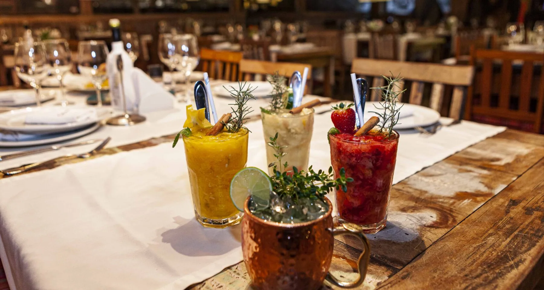 Mesa de madeira com taças e bebidas na Luciana Valladão